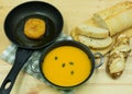 Pumpkin soup in a pot and patty in a pan with ciabatta Royalty Free Stock Photo