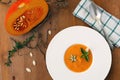 Pumpkin soup, seeds, bread and basil in plate on wood background Royalty Free Stock Photo