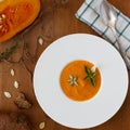 Pumpkin soup, seeds, bread and basil in plate on wood background Royalty Free Stock Photo