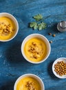 Pumpkin soup with spicy baked chickpea. On a wooden table, top view. Delicious vegetarian lunch.