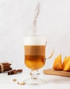 Pumpkin spice latte in a glass mug, cinnamon powder falling Royalty Free Stock Photo