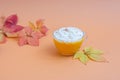 Pumpkin spice latte in a glass mug with whipped cream on  beige background. Autumn leaves. Hot autumn drink. Royalty Free Stock Photo