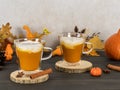 Pumpkin spice latte in glass mugs with cinnamon, nutmeg, and whipped cream.