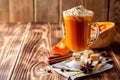 Pumpkin spice latte with whipped cream and cinnamon in glass on rustic wooden background Royalty Free Stock Photo