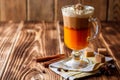 Pumpkin spice latte with whipped cream and cinnamon in glass on rustic wooden background Royalty Free Stock Photo