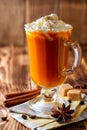 Pumpkin spice latte with whipped cream and cinnamon in glass on rustic wooden background Royalty Free Stock Photo