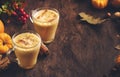 Pumpkin spiced latte or coffee in glass cup on vintage wooden table. Autumn or winter hot drinks and beverages. Fall decor table Royalty Free Stock Photo