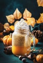 Pumpkin spiced latte or coffee in glass jar on blue table. Autumn or winter hot drink in festive natural table setting with orange Royalty Free Stock Photo