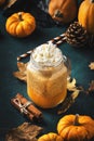 Pumpkin spiced latte or coffee in glass jar on blue table. Autumn or winter hot drink in festive natural table setting with orange Royalty Free Stock Photo