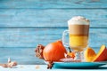 Pumpkin spiced latte or coffee in glass on turquoise wooden table. Autumn, fall or winter hot drink. Royalty Free Stock Photo