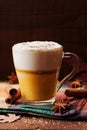 Pumpkin spiced latte or coffee in a glass on a wooden table. Autumn or winter hot drink. Royalty Free Stock Photo