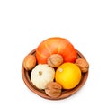 Pumpkin and walnuts in a clay bowl isolated on a white background. Place for your text