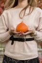 Pumpkin in woman hand out door