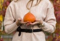 Pumpkin in woman hand out door