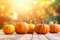 Pumpkins and autumn leaves on white wooden table, blurry background with copy space