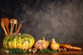 Pumpkins, butternut squash, mushrooms with cooking ustencils and rolling pin on a table over a vintage background with copy space
