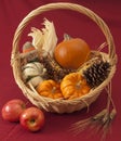 Pumpkins, corn, and scarecrow doll in basket