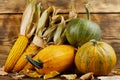 Pumpkins with corn on a wooden background. Royalty Free Stock Photo