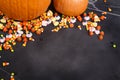 Pumpkins and Halloween candy scattered over a black chalkboard