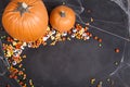 Pumpkins and Halloween candy scattered over a black chalkboard