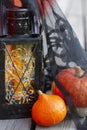 Pumpkins and Halloween style vintage lamp with black cover, orange candle and yellow lights.