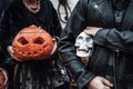 Pumpkins jack-o-lantern and skull in hands. Scary family father,daughter celebrating halloween. Stylish witch costumes, images.