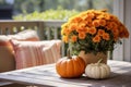 Pumpkins near yellow flowers bouquet on a table. Farmhouse autumn centerpiece on blurred background. Cottagecore aesthetic Royalty Free Stock Photo