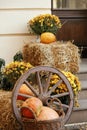 Pumpkins with rustic baskets, flowers and hay decoration outdoors. Stylish autumn decor of exterior Royalty Free Stock Photo