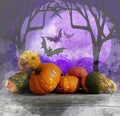 Pumpkins and squashes on rustic wooden boards with halloween background