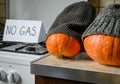 Pumpkins in winter knit hats on Halloween at cold home, expensive gas and electricity for heating Royalty Free Stock Photo