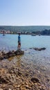 Punat - Young man standning on a rocks in a shallow sea water Royalty Free Stock Photo