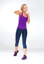 Punch bad habits out of the way. Studio shot of an attractive young woman in exercise clothing against a gray background