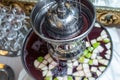 A punch fountain with lights and red drink on a table.