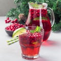 Punch or limeade with lingonberry and lime in a glass and pitcher on a gray background, square Royalty Free Stock Photo