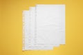 Punched pockets with paper sheets on yellow background, flat lay. Space for text Royalty Free Stock Photo