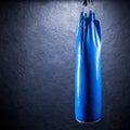 Punching bag blue against a plastered wall