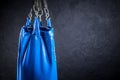 Punching bag blue against a plastered wall