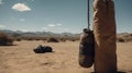 A punching bag is hanging on a rope in the sand desert outdoors. Boxing gloves on the sand