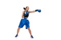 Dynamic portrait of young girl, professional boxer practicing in boxing gloves isolated on white studio background