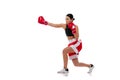 Dynamic portrait of young girl, professional boxer practicing in boxing gloves isolated on white studio background