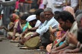 Pune, India - July 11, 2015: Hungry pilgrims called warkaris wait to be served on the streets during the famous