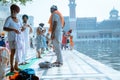 Punjabi Sikh pilgrim devotee changing traditionla dress before holy bath in pond in front Golden Temple