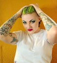 Punk girl with attitude. Green hair, tattoos, facial piercings. 