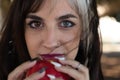 Punky girl with blonde and brunette hair holds a red apple in her hands and stares at it. The girl is a witch from the fairy tale Royalty Free Stock Photo