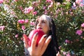 Punky girl with blonde and brunette hair holds a red apple in her hands and stares at it. The girl is a witch from the fairy tale Royalty Free Stock Photo