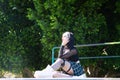 Punky girl is sitting with her skateboard on a skateboarding platform. The girl is resting. Concept skating or skateboarding Royalty Free Stock Photo