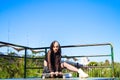 Punky girl is sitting with her skateboard on a skateboarding platform. The girl is resting. Concept skating or skateboarding Royalty Free Stock Photo