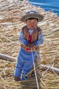 Puno, Peru - circa June 2015: Small boy in traditional clothes at Uros floating island and village on Lake Titicaca near Puno, Pe Royalty Free Stock Photo