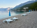 Punta Rata Beach in the Croatian resort of Brela. Empty sun loungers and umbrellas on the beach. Beautiful Adriatic Sea landscape