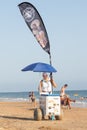 Punta Umbria, Huelva, Spain - August 7, 2020: A female street vendor selling ice cream in the beach. Seller is wearing protective